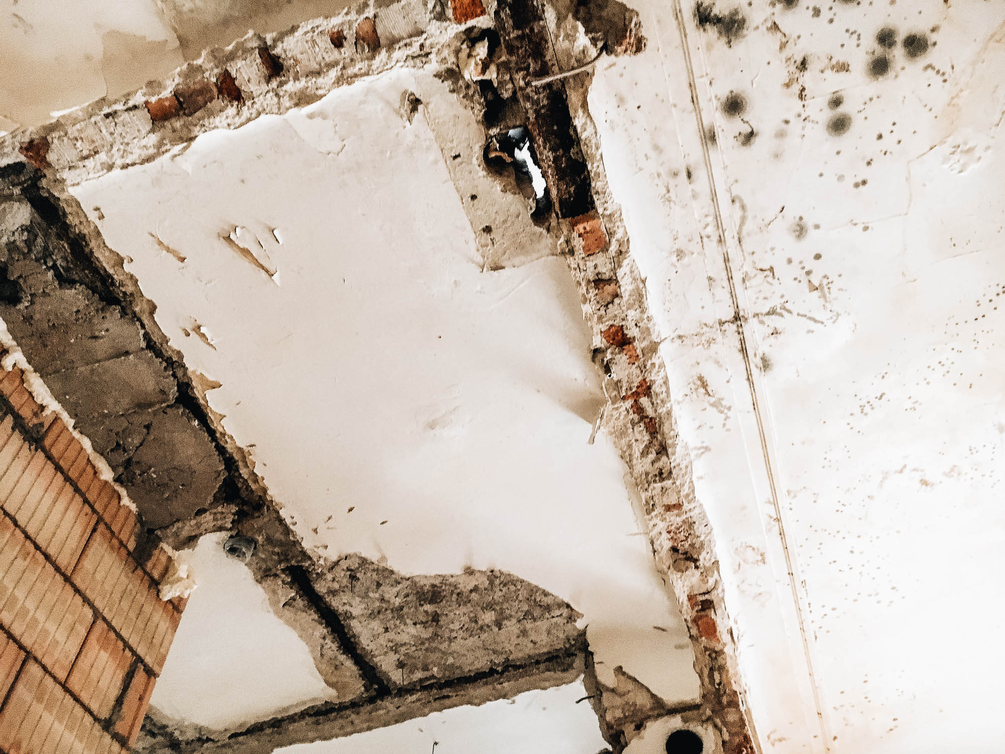 Odstraňování starých stropních vrstev při rekonstrukci bytu — odkrytí původní konstrukce a souvrství materiálů z různých stavebních etap, dokumentace procesu bourání