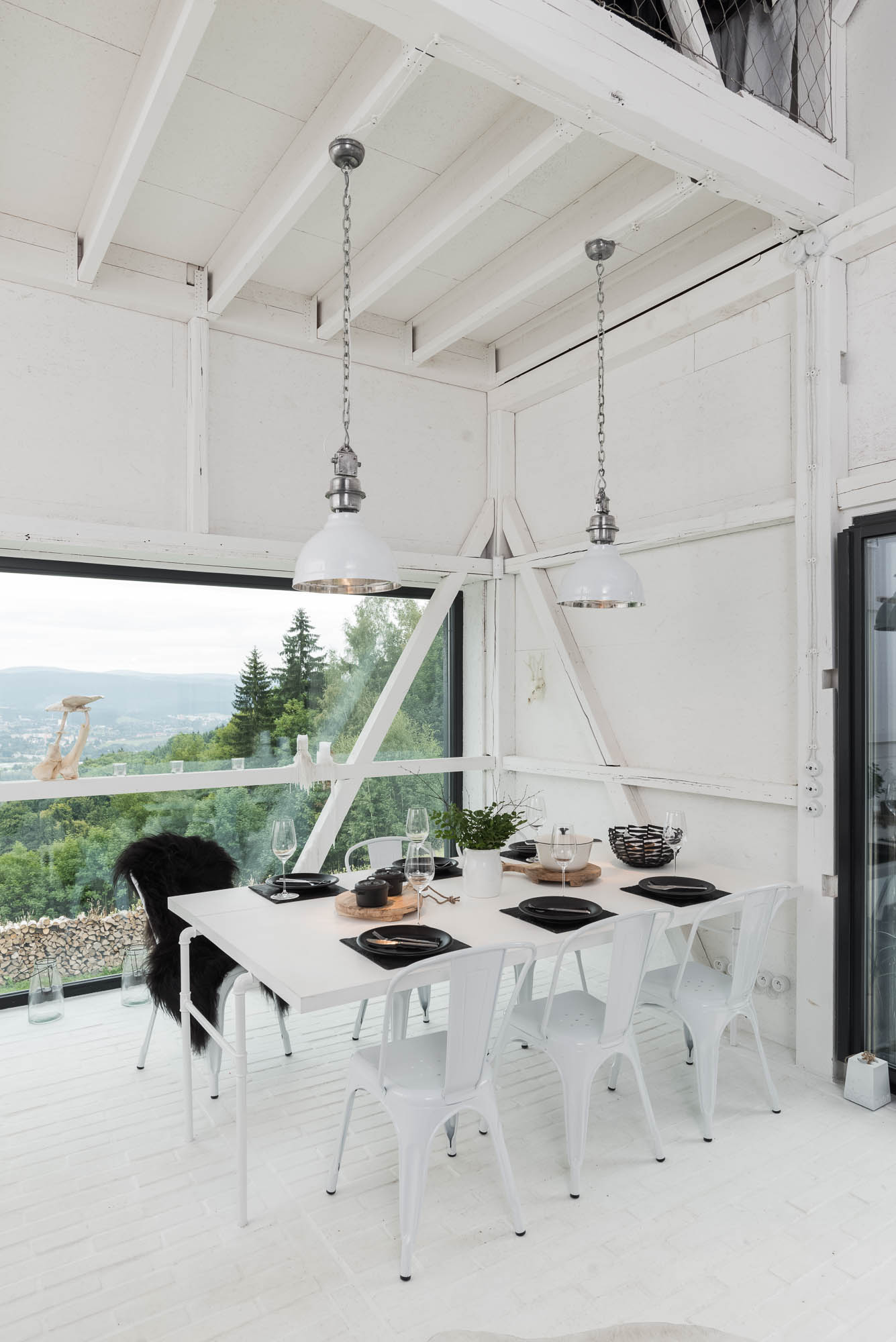 BOX white barn dining area — set table with black dishes, white Tolix chairs, industrial pendant lamp, panoramic barn window | OOOOX