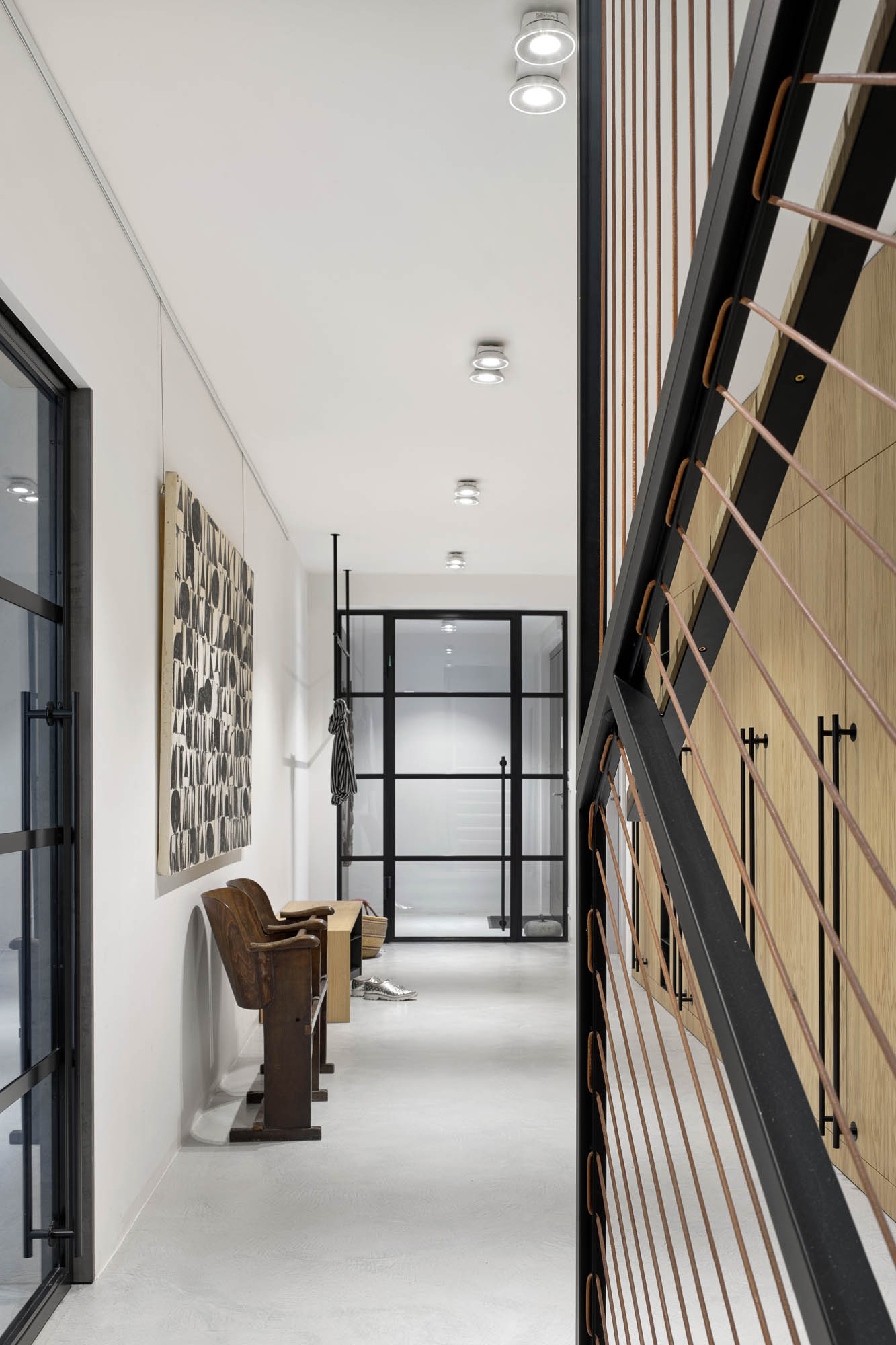 Entrance hall black steel glass pivot door leather cord stair balustrade abstract circles art print OOOOX