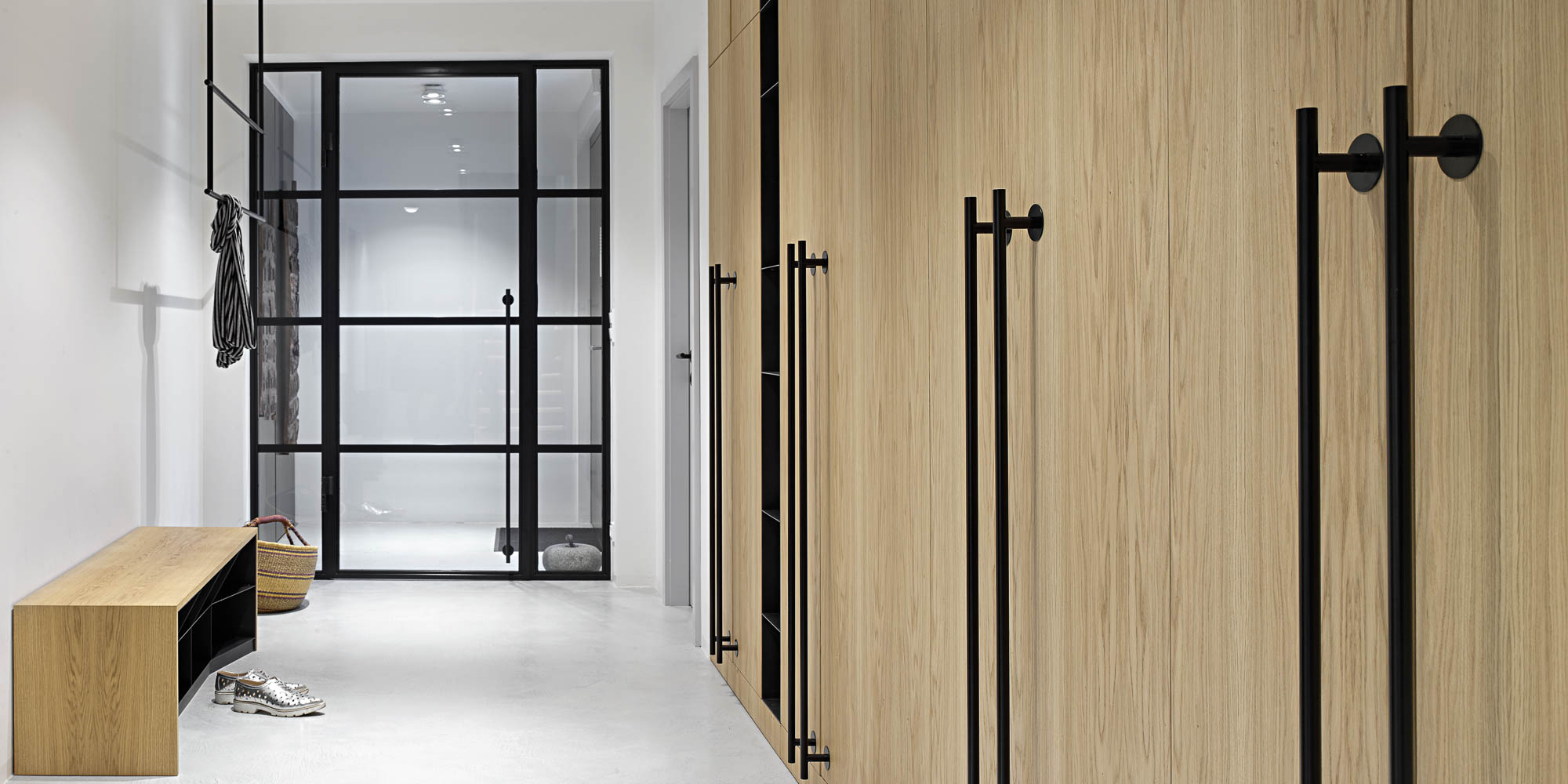 Entrance hall oak built-in wardrobe black bar handles suspended coat rail glass pivot door OOOOX villa