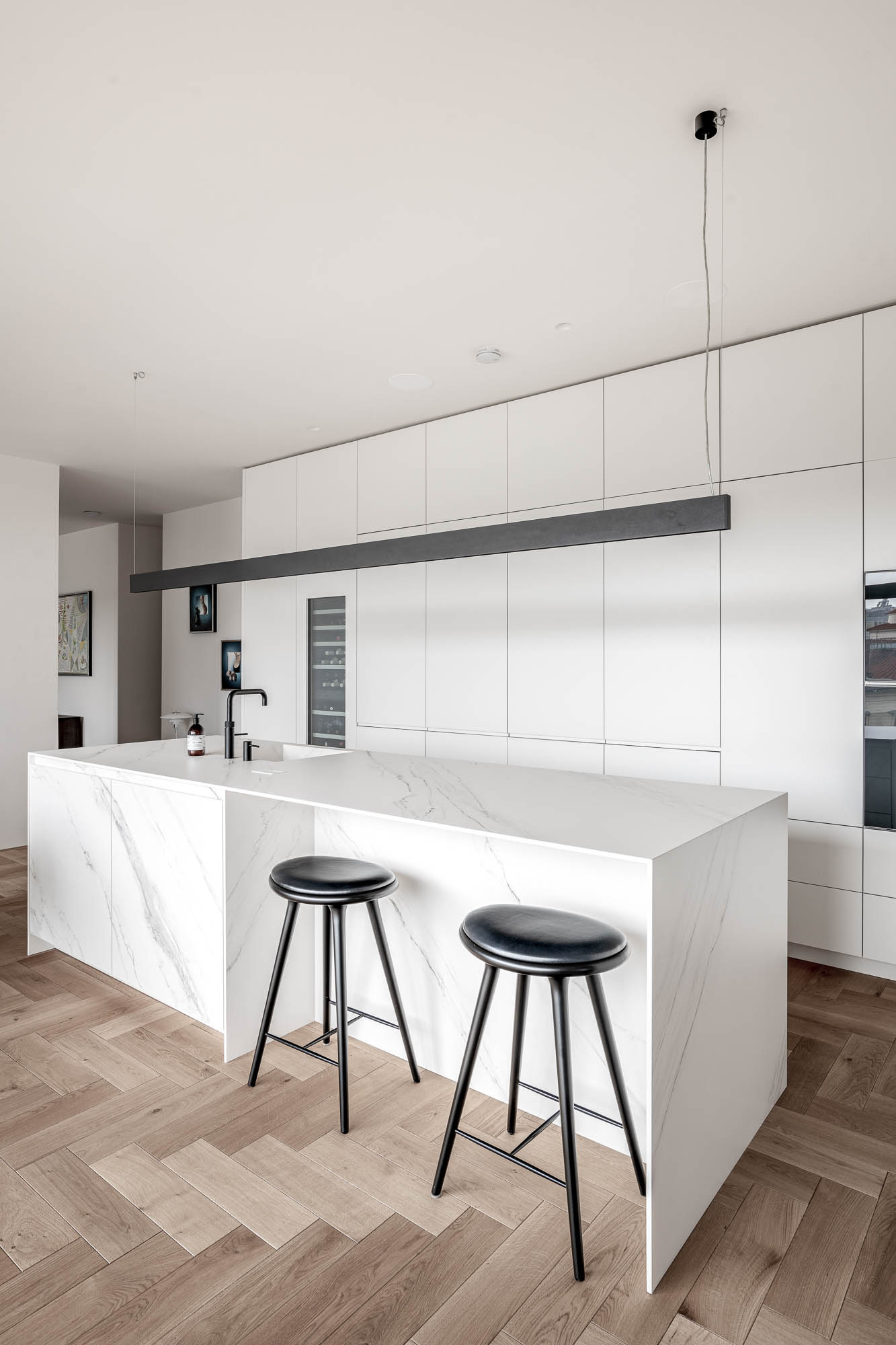 Kuchyně s mramorovým ostrůvkem a bílou vestavbou
