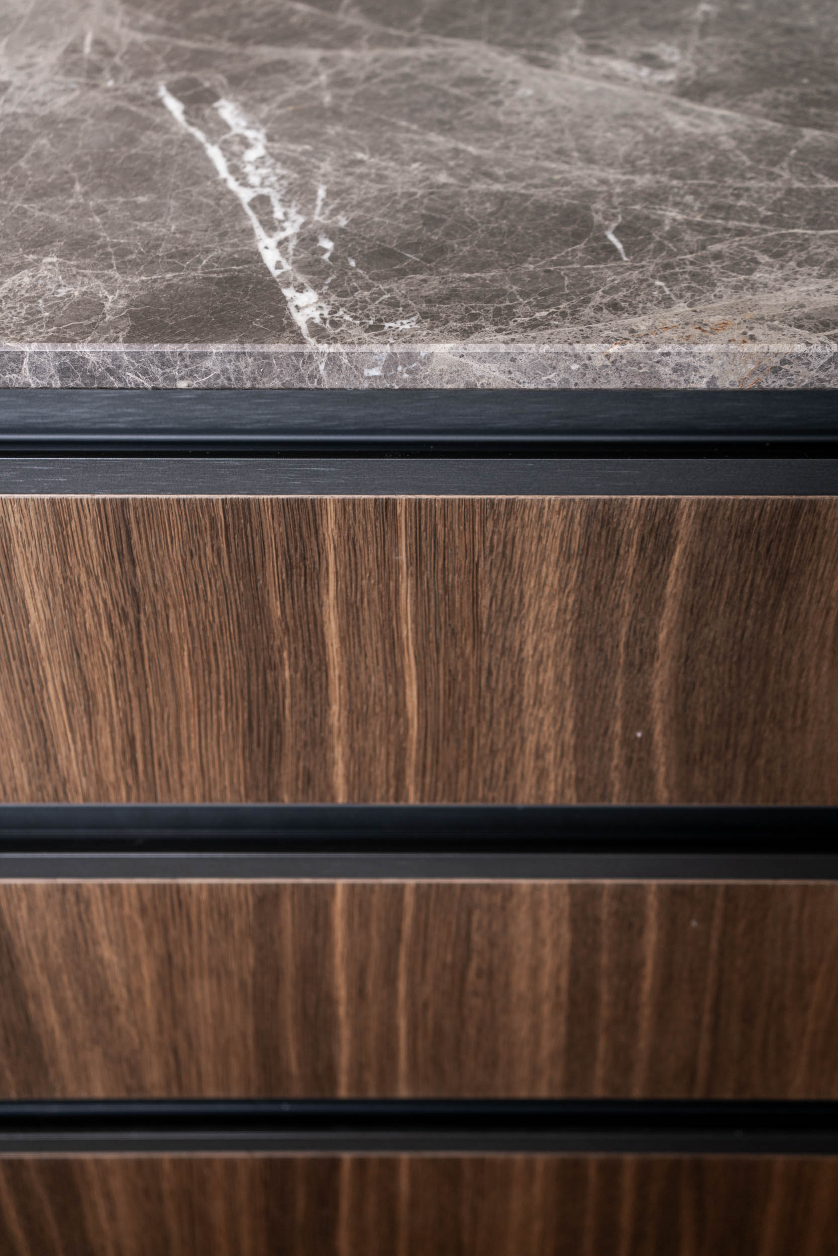 Detail of a bar kitchen island with a marble countertop and veneered drawers – minimalist interior of Villa Vinohrady | OOOOX