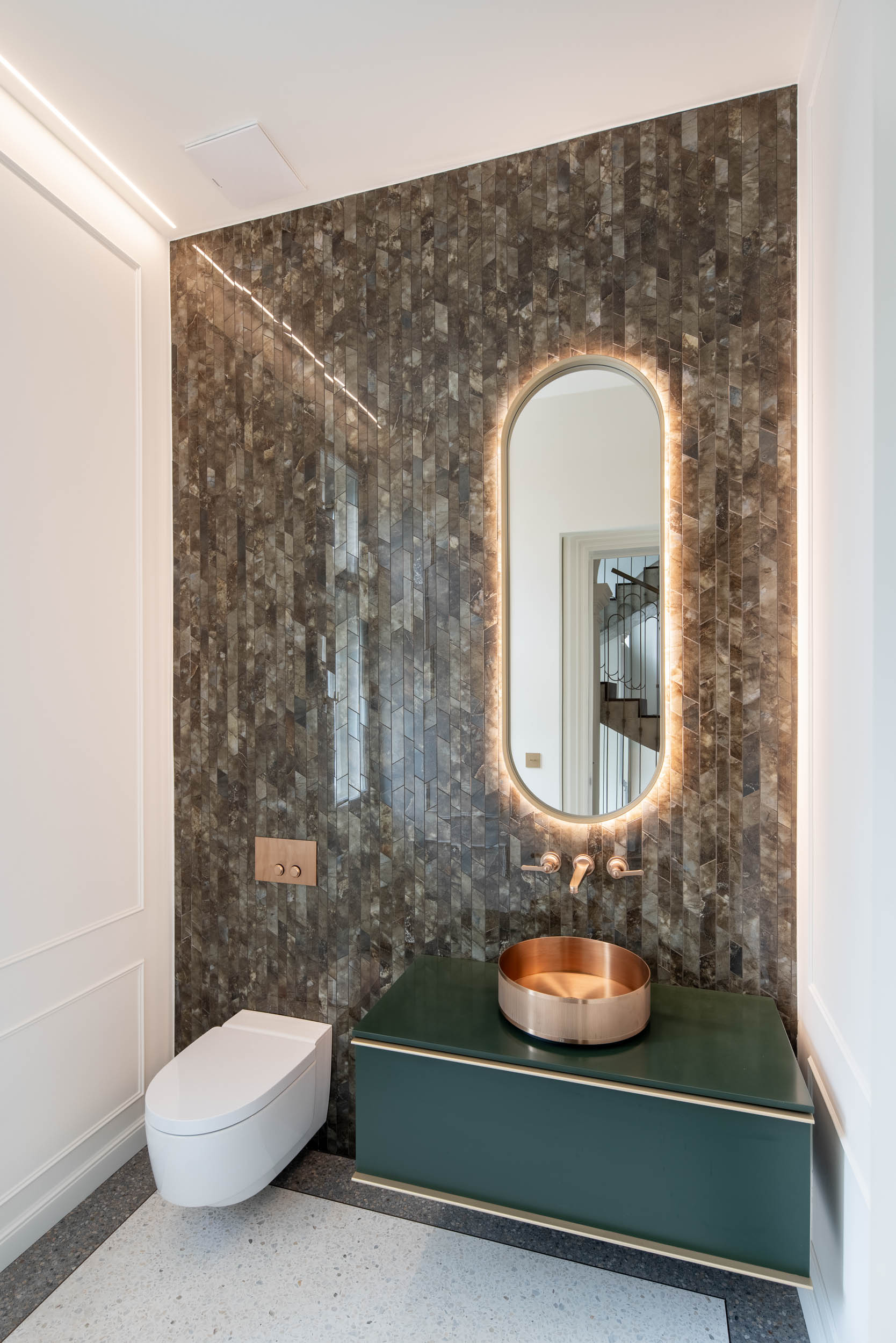 Bathroom clad in green marble stone mosaic with a brass sink and faucets inspired by the 1930s | Villa Vinohrady reconstruction design by OOOOX
