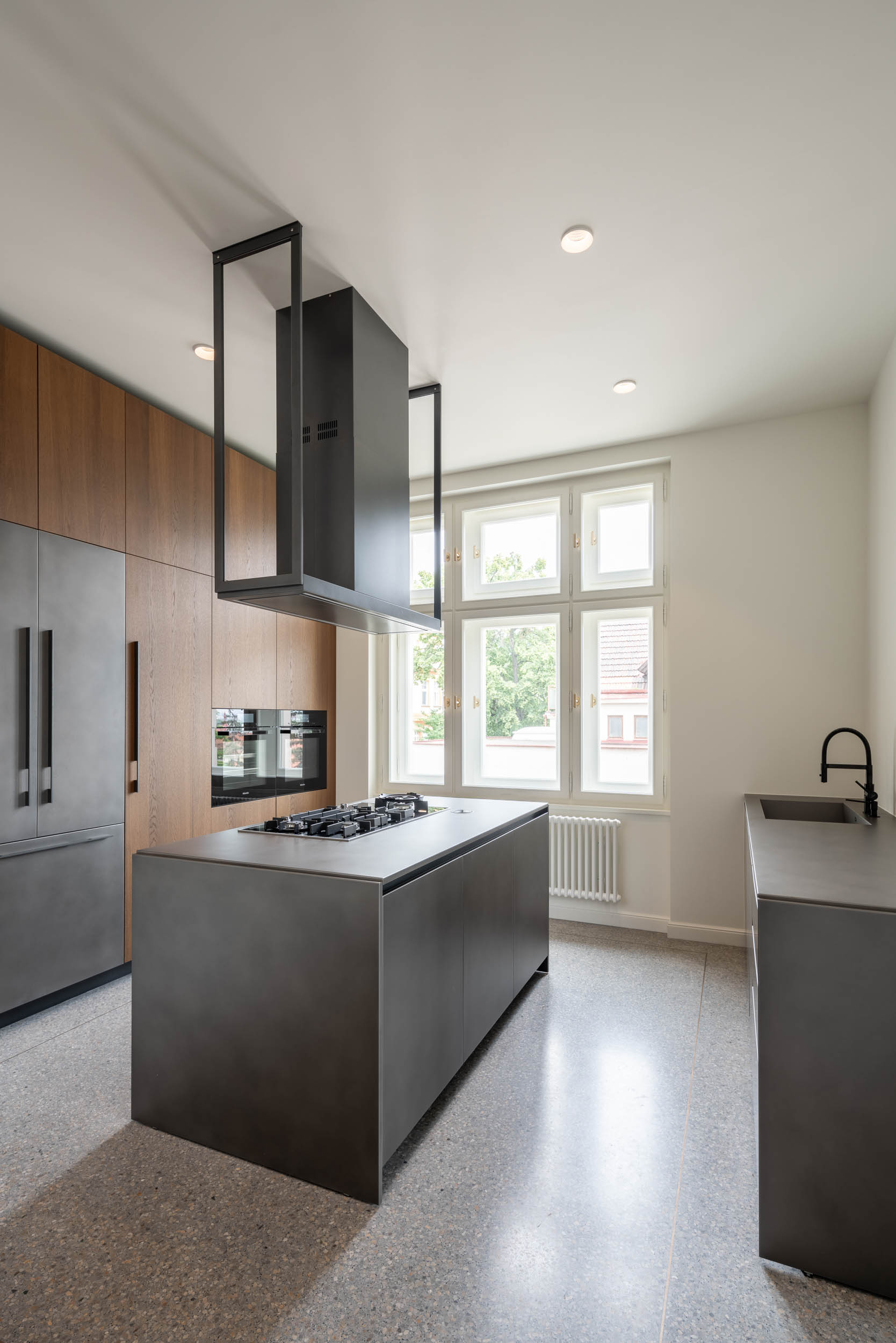 Secondary working kitchen with tall cabinets, kitchen island and designer extractor hood | Villa Vinohrady reconstruction by OOOOX