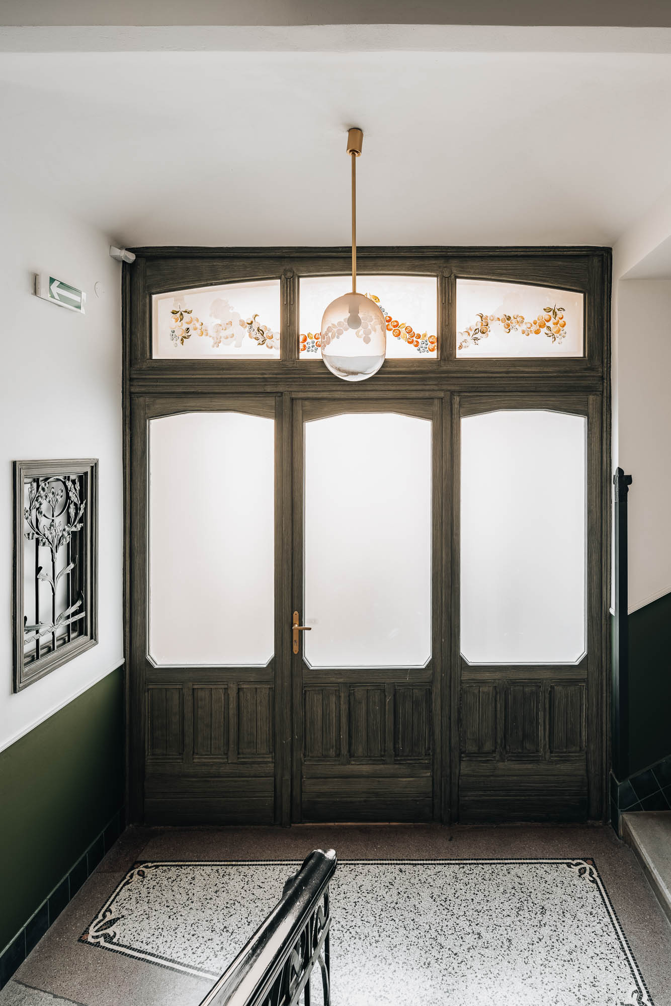 Společný prostor činžovního domu Mánesova, terrazzo na podlaze, historické dveře a designové svítidlo | návrh a rekonstrukce od OOOOX