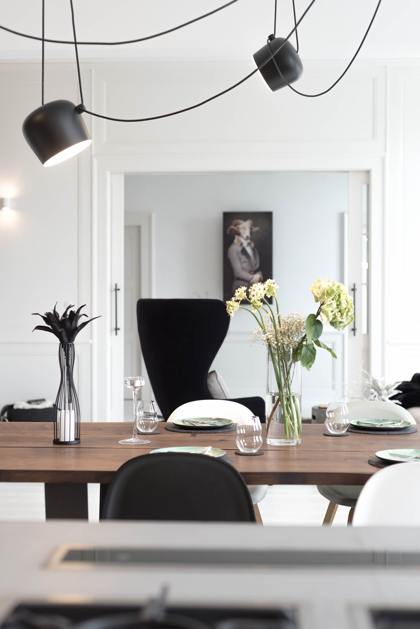 Detail of a three-metre solid walnut dining table and designer light fixture above the table | Art Nouveau apartment interior reconstruction by OOOOX