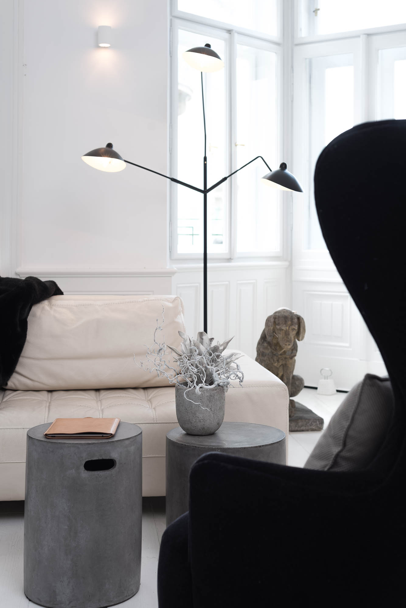 Detail of a living room with a designer sofa and concrete coffee table | apartment reconstruction design by OOOOX