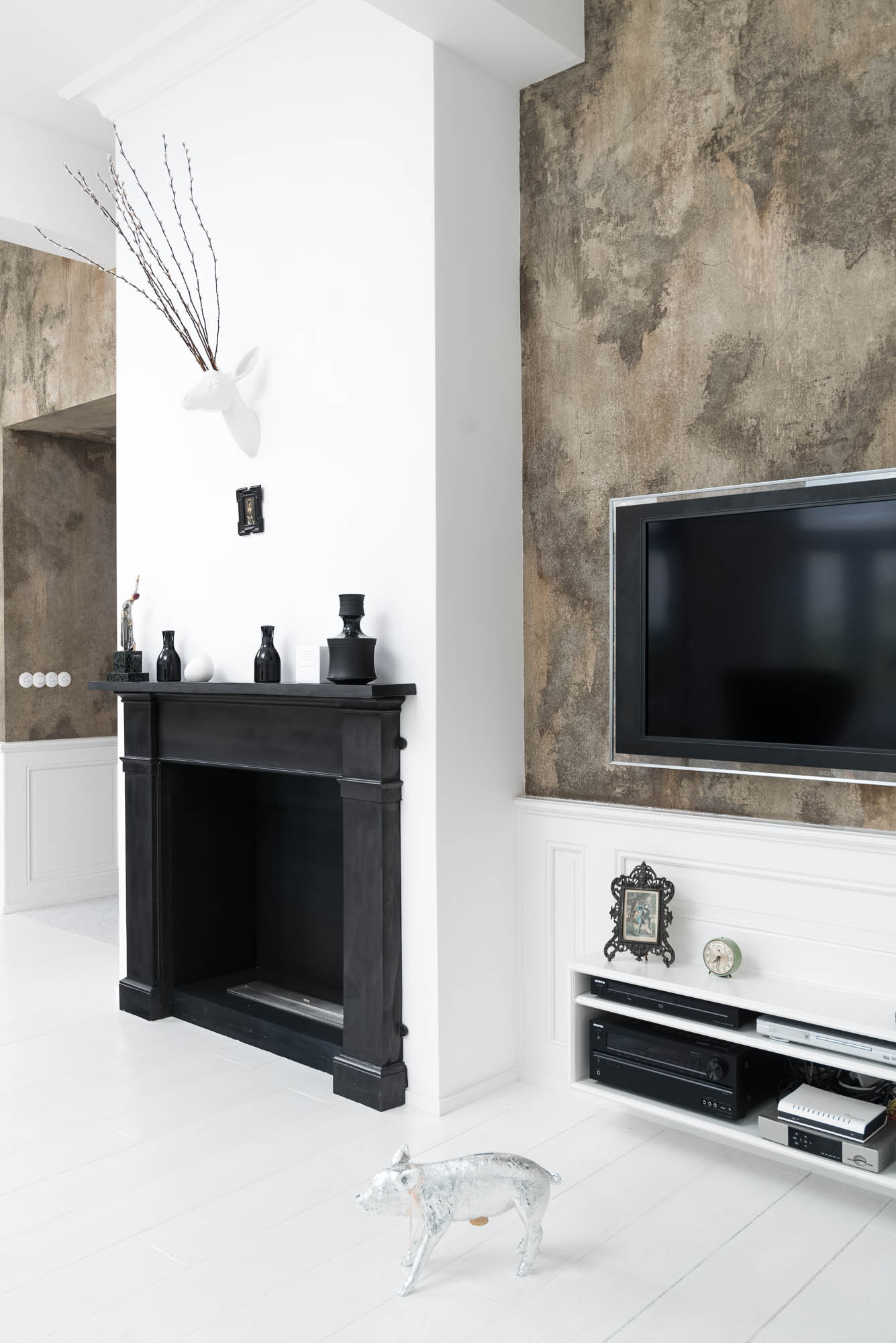 Black Victorian fireplace with a bioethanol insert in the living space of an Art Nouveau apartment interior, textured wall painting and white flooring | reconstruction design by OOOOX