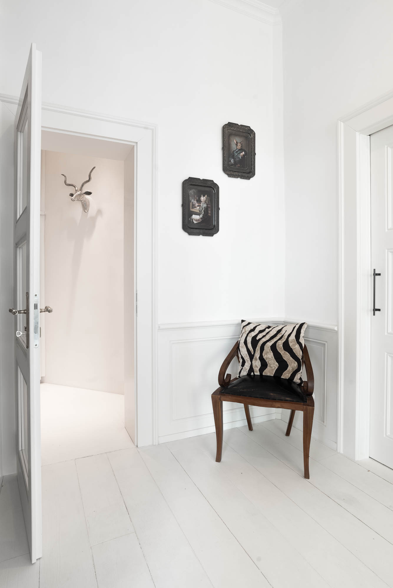 Detail of a designer door handle and designer armchair in the hallway of an Art Nouveau apartment | OOOOX