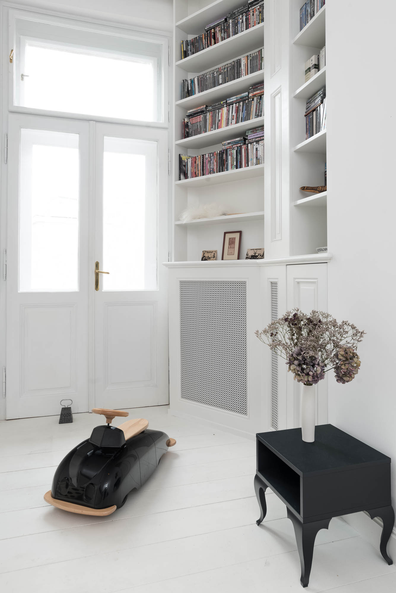 Children’s room in white tones with wall panelling, built-in furniture and a full-wall bookshelf | interior and reconstruction of an Art Nouveau apartment by OOOOX
