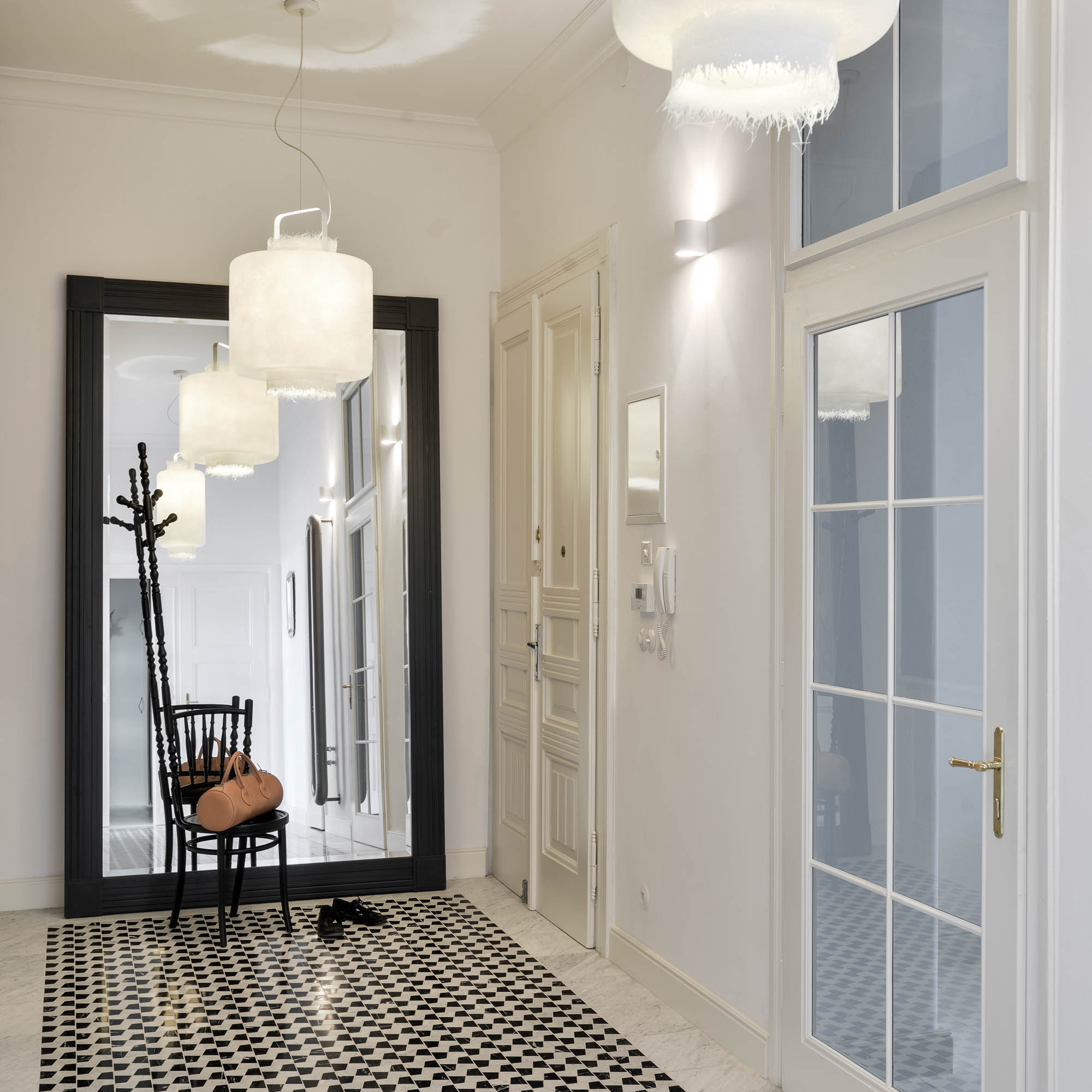 Entrance hall in the TIVOLI Art Nouveau apartment interior, stone mosaic flooring made from three marble colours and contrasting fibreglass light fixtures | reconstruction design by OOOOX