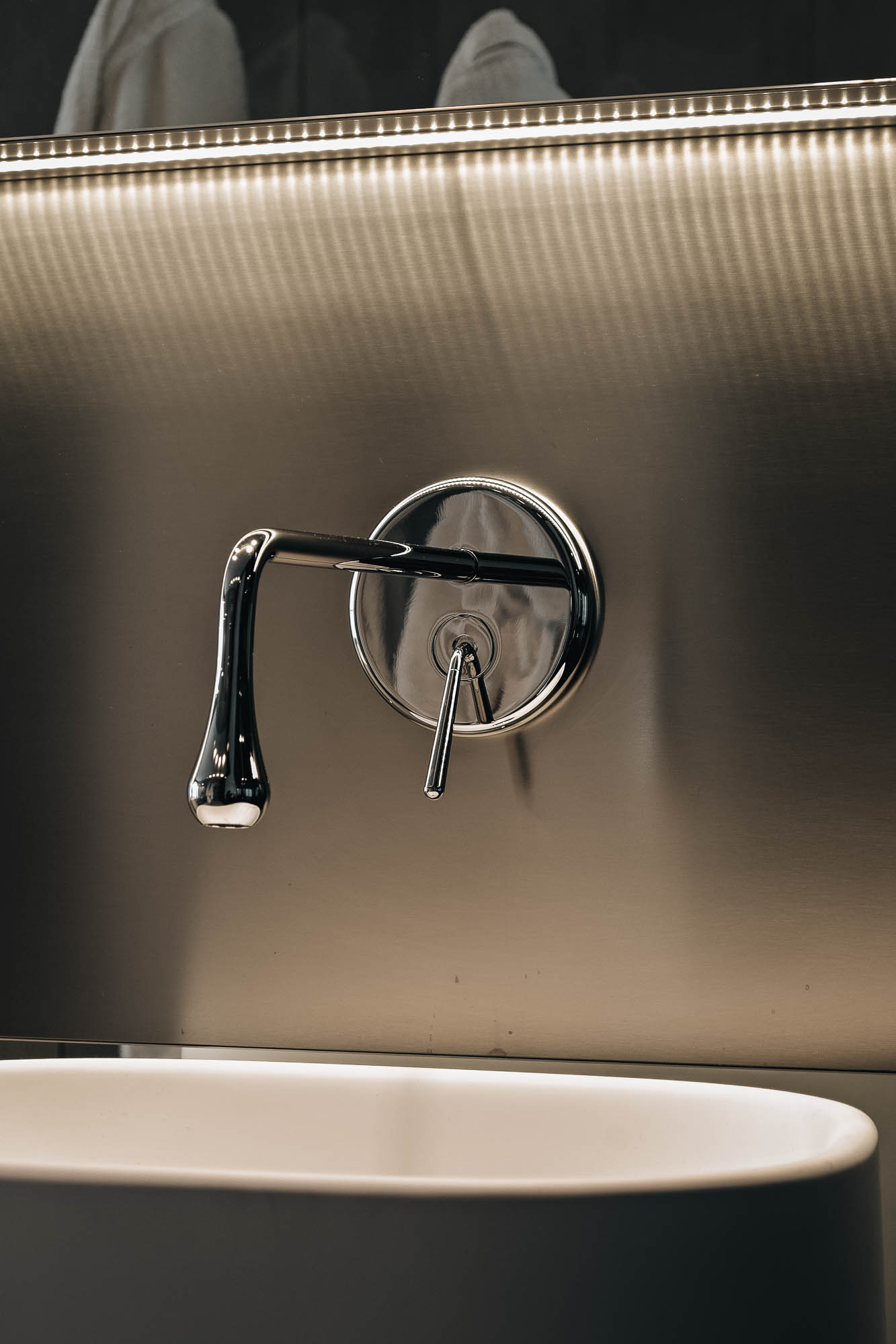 Detail designové nástěnné baterie na nerezové desce s LED páskem v koupelně interiéru vily, OOOOX