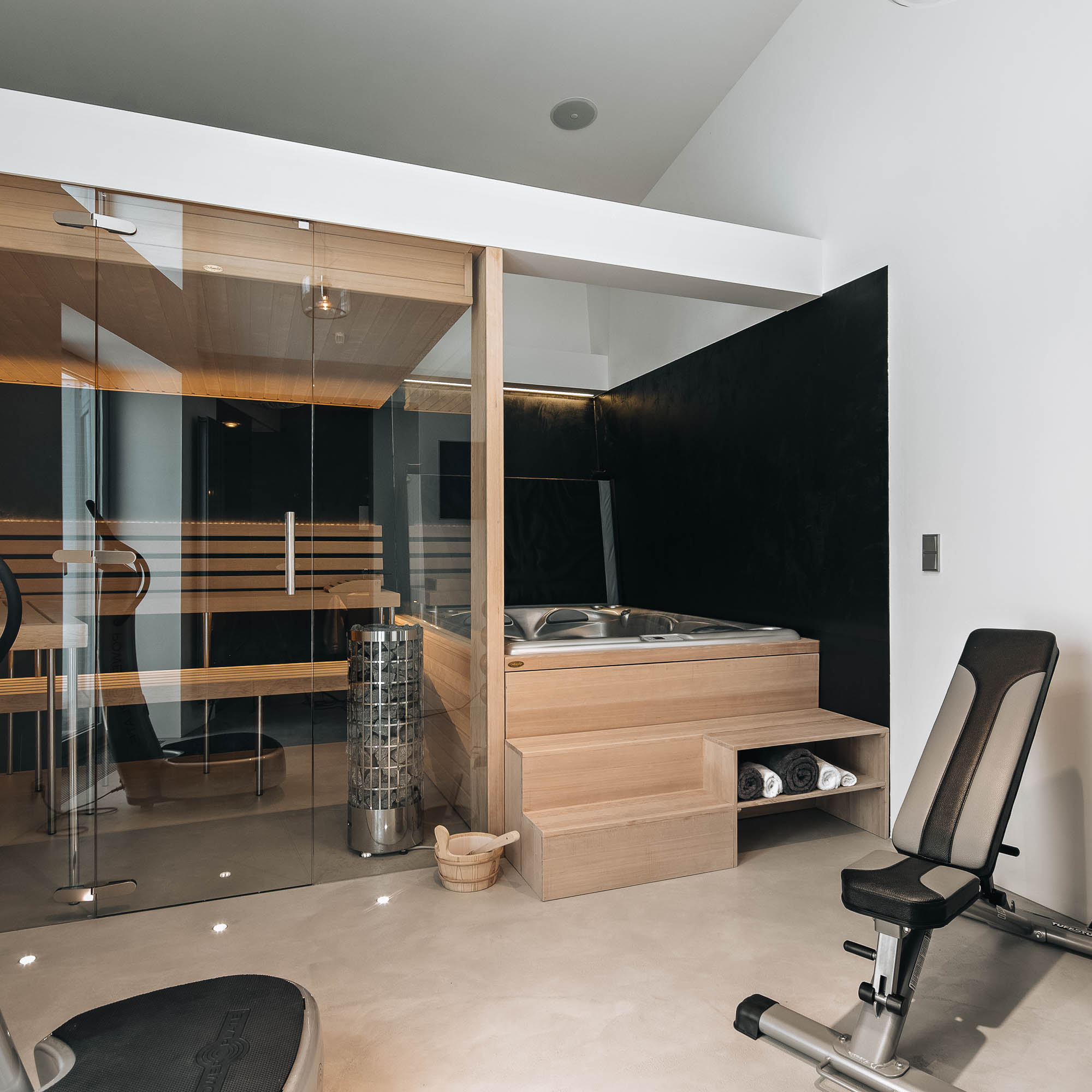 Wellness zóna vily s finskou saunou, vířivkou a fitness vybavením – pohledový beton a světlé dřevo, OOOOX