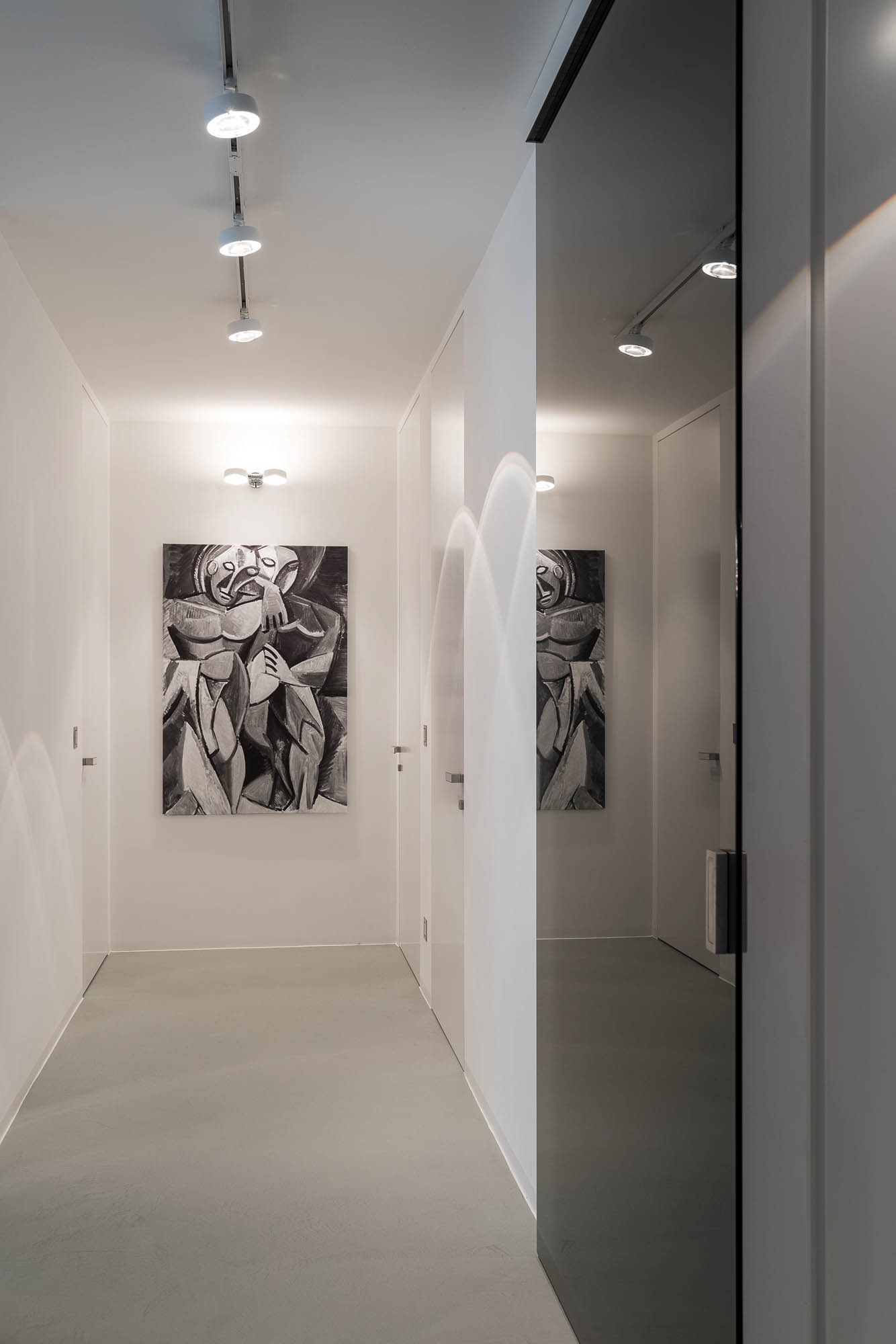 Designová minimalistická chodba s prosklenými posuvnými dveřmi v tmavém provedení – interiér minimalistického bytu | OOOOX