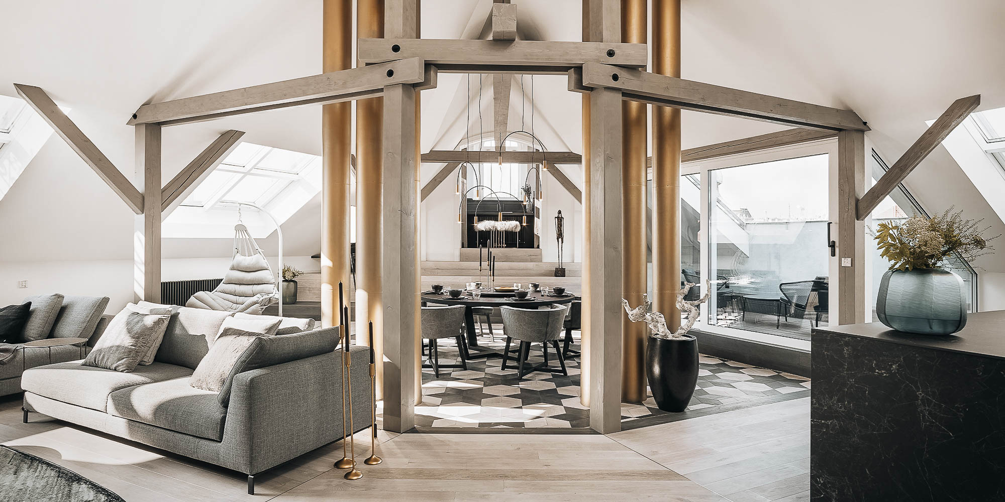 Open living room with a view into the dining area through the original brass chimneys – interior reconstruction design of the Josefov attic apartment | OOOOX