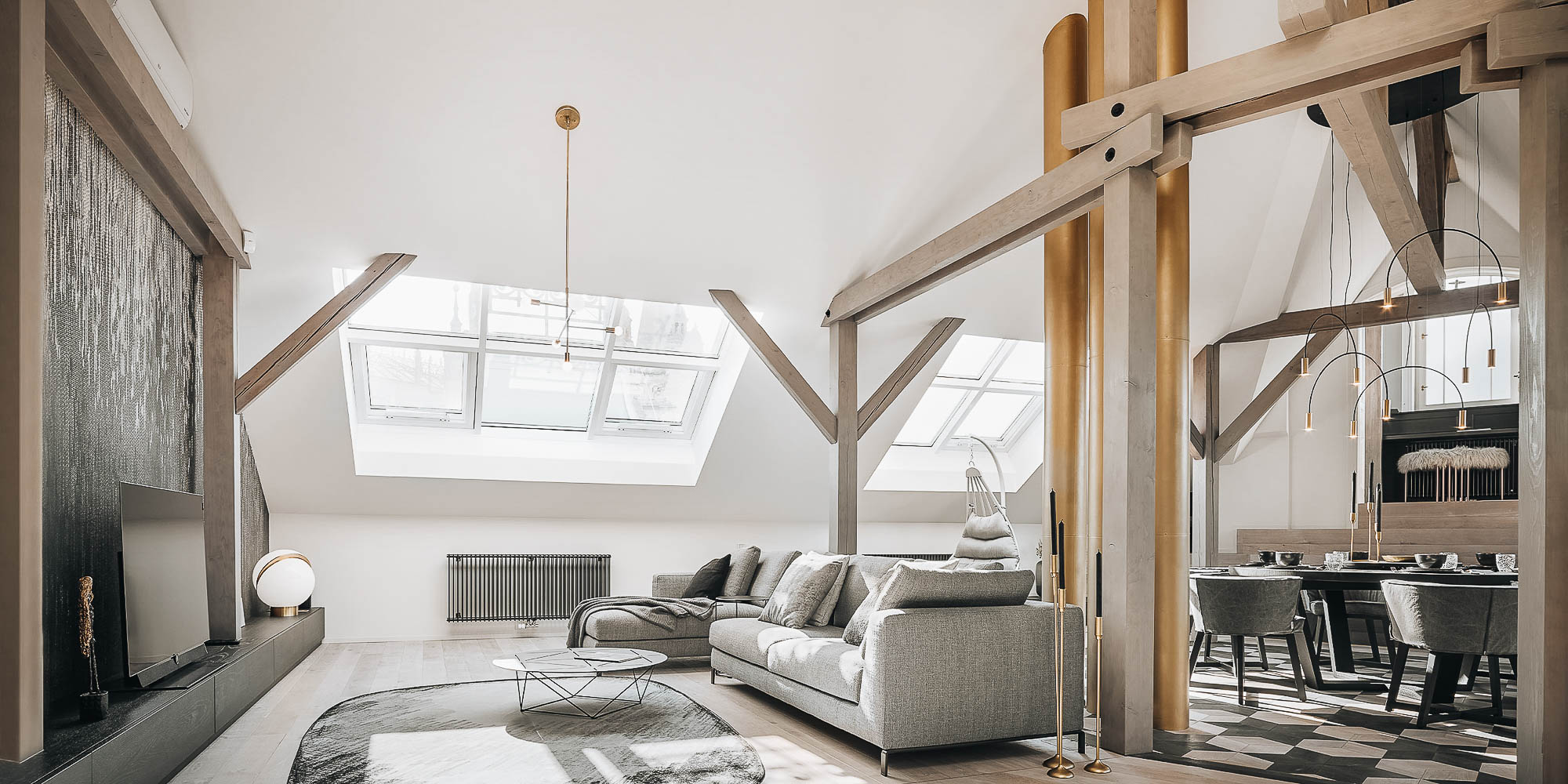 Open living room of the Josefov attic apartment with original chimneys as the dominant feature of the space | design by OOOOX