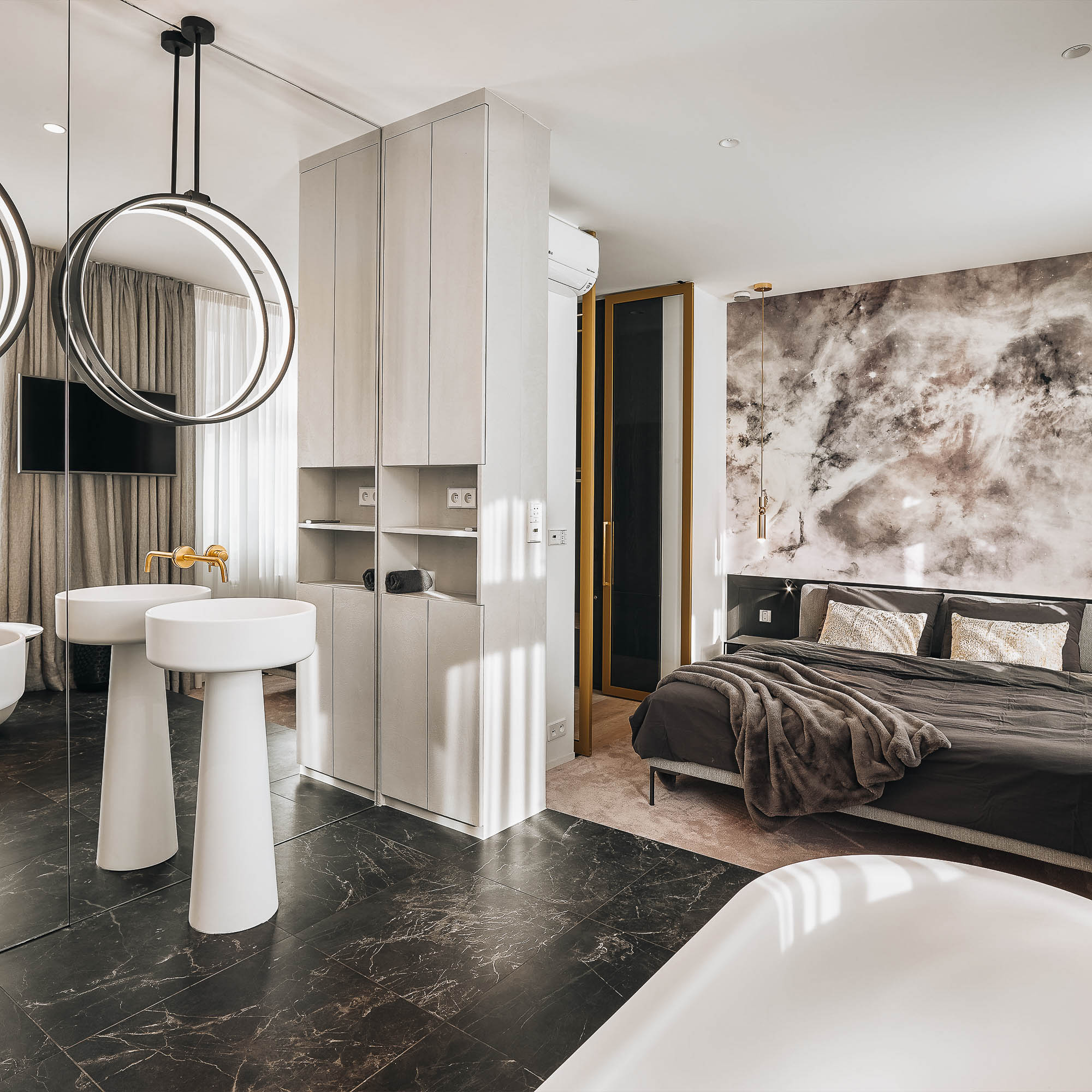 Bedroom connected to an open bathroom, two freestanding sinks and circular light fixtures creating the illusion of an optical mirror | design by OOOOX