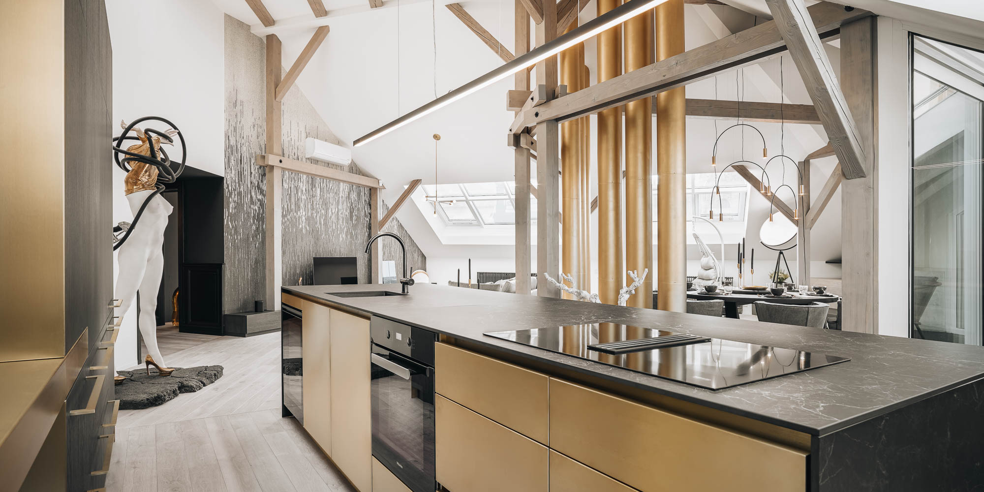 Detail of a kitchen island with metal laminate veneer in a brass finish, brass chimneys as the dominant feature of the space | OOOOX