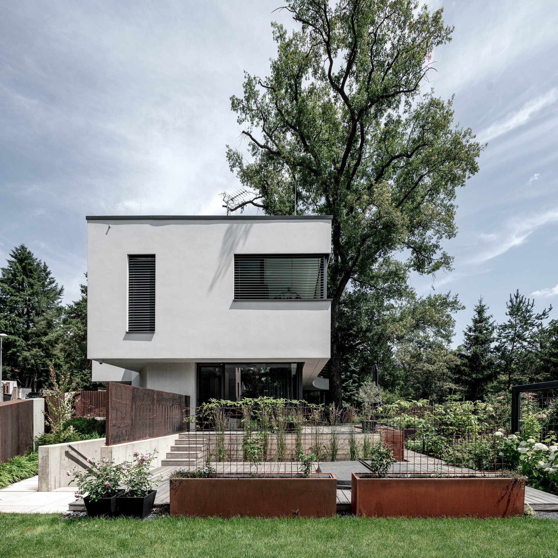 Exterior view of Villa Lučiny with white facade and minimalist architectural design. Design by OOOOX