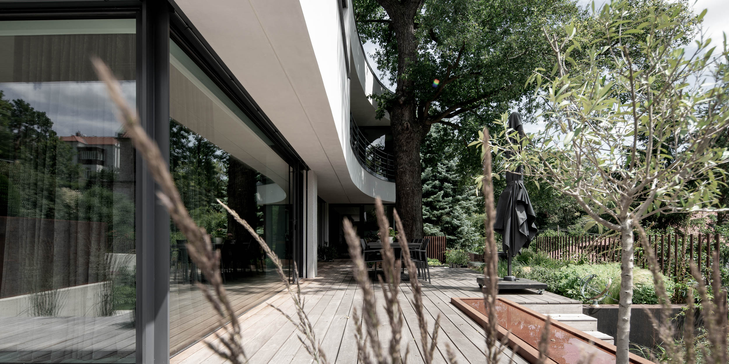 Exteriérový pohled na vilu Lučiny s bílou fasádou a minimalistickým architektonickým řešením. Design by OOOOX