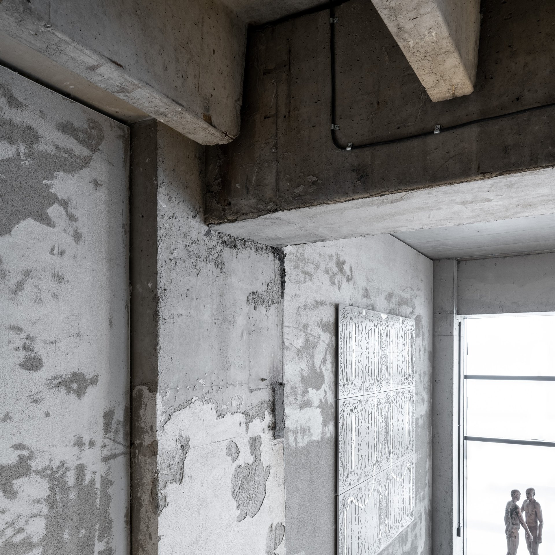 Architektonický detail napojení betonové konstrukce – přiznaný železobeton s viditelnými průvlaky, bednícími stopami a texturovanou omítkou loftového bytu Vanguard. OOOOX