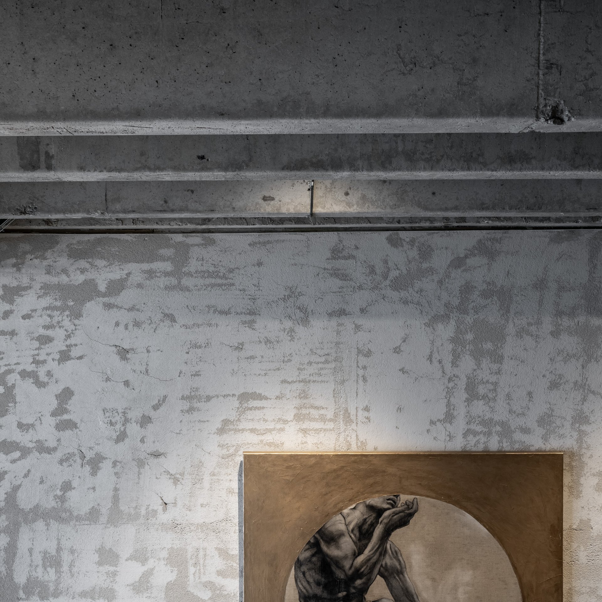 Detail figurativní malby na syrové betonové stěně továrny s přiznanými průvlaky – součást kurátorského výběru umění pro vzorový loft Vanguard. OOOOX