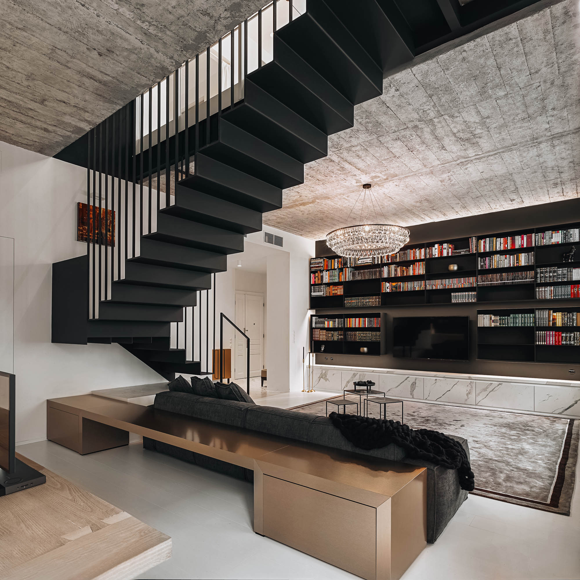View from above black steel floating staircase oak bronze sofa platform crystal chandelier concrete ceiling OOOOX